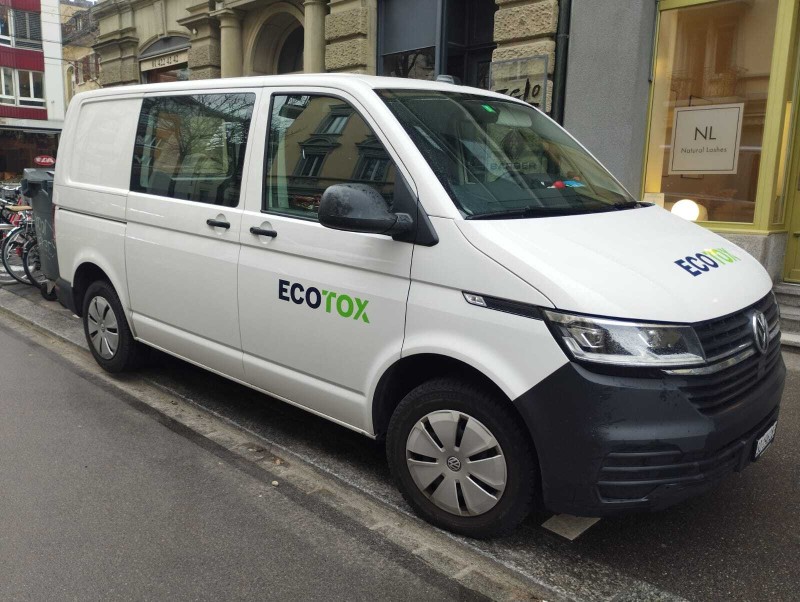 Une camionnette blanche Ecotox est gar&eacute;e le long d&rsquo;une rue du canton de Vaud, pr&ecirc;te pour une mission de lutte antiparasitaire ou de d&eacute;sinfection.